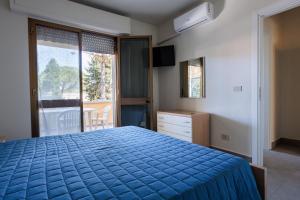 a bedroom with a bed with a blue comforter at IL TRITONE in Marina di Bibbona