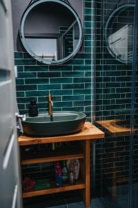 a bathroom with a green sink and a mirror at genius loci apartments in Levoča