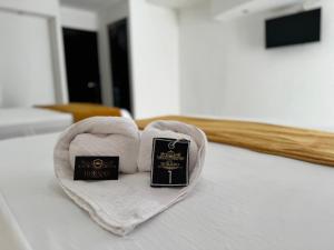 a heart shaped towel on a bed with a book at Hotel DORADO in Tapachula