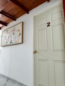 a white door in a room with a painting on the wall at Hotel DORADO in Tapachula +6 photos