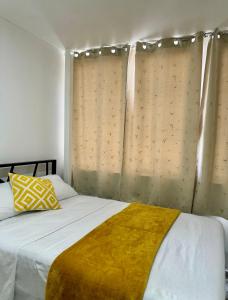 a bedroom with a bed with a yellow blanket at Hotel DORADO in Tapachula