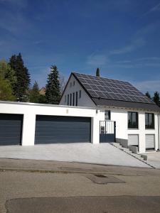 a white house with solar panels on it at Ferienhaus Traumblick-Neustadt in Neustadt an der Weinstraße