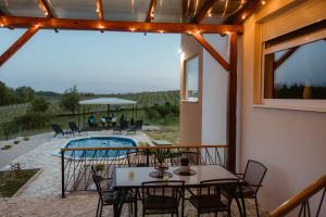 a patio with tables and chairs and a pool at Vinewood in Grabrovnik