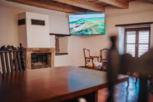 a living room with a table and a tv on the wall at genius loci apartments in Levoča