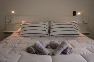 a white bed with pillows on top of it at Viento Sur Anfitrionas "Centro" in Puerto Madryn
