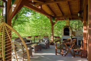 a pavilion with a table and chairs and a fireplace at Mountain harmony Lovćen in Cetinje