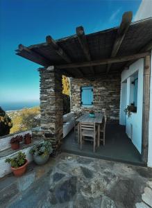 a patio with a table and chairs on a building at Vista Tinos in Triandáros