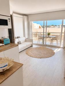 a living room with a couch and a table at A 2 passi dal mare! in Es Pujols