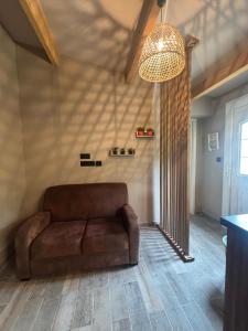 a brown couch in a living room with a ceiling at A fontanille in Magalas