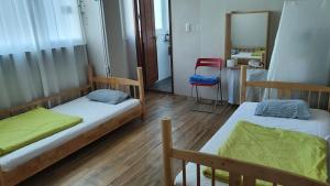 a room with two beds and a chair in it at Welcome Busan Guesthouse in Busan