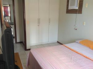 Apartamento Senador Ruy Carneiro في جواو بيسوا: غرفة نوم بسرير ودواليب بيضاء