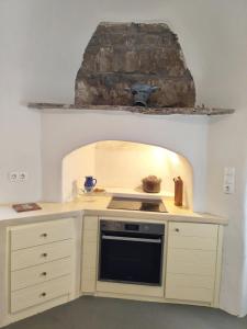 a kitchen with a stove top oven next to a wall at Vista Tinos in Triandáros
