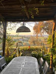 a wooden table with chairs and a chandelier at Casa Melissa in Santo António do Baldio