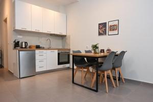 a kitchen with a table and chairs in a room at Omonoia Central Apartment in Kavála