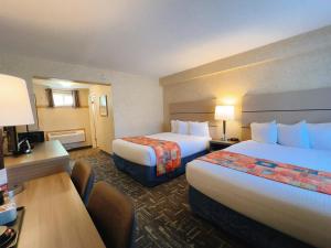 a hotel room with two beds and a desk at North Vancouver Hotel in North Vancouver