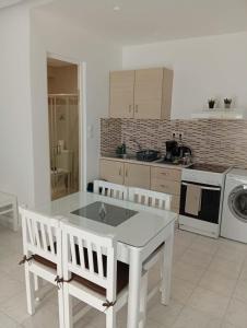 a kitchen with a white table and two white chairs at Casa al'tati studio 27 in Ialysos