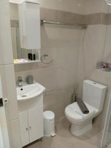 a white bathroom with a toilet and a sink at Casa al'tati studio 27 in Ialysos