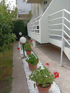 a garden with flowers in pots next to a staircase at Casa al'tati studio 27 in Ialysos