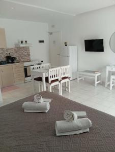 a living room with a kitchen and a table with towels at Casa al'tati studio 27 in Ialysos