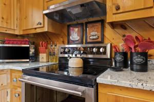 a stove top oven in a kitchen with wooden cabinets at Hearts Hideaway in Morganton