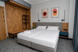a bedroom with a large white bed and a wooden door at Lofft Hotel in Ciechanów