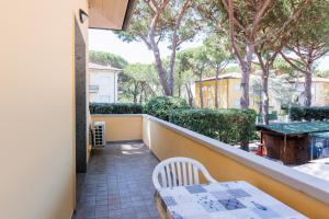 a balcony with a table and chairs and trees at IL TRITONE in Marina di Bibbona