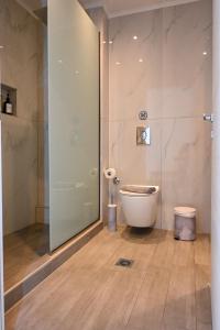 a bathroom with a toilet and a glass shower at Omonoia Central Apartment in Kavála +35 photos