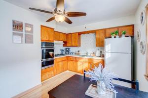 a kitchen with wooden cabinets and a white refrigerator at King Bed • 2BR • Sleeps 13 • Historic Location in Elmwood Park