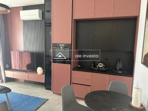 a dining room with pink cabinets and a table at Green Coast 244d - by Ale Investa in Palasë