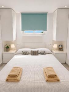 a bedroom with a bed with two towels on it at A 2 passi dal mare! in Es Pujols