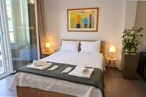 a bedroom with a bed with towels on it at Omonoia Central Apartment in Kavála