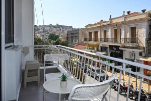a balcony with a table and chairs and a city at Omonoia Central Apartment in Kavála
