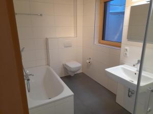 a bathroom with a sink and a tub and a toilet at Ferienhaus Traumblick-Neustadt in Neustadt an der Weinstraße +15 photos