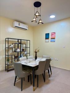 a dining room with a table and chairs at Deluxe Apartment in Muscat