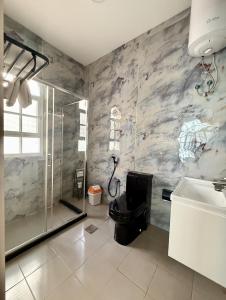 a bathroom with a shower and a toilet and a sink at Deluxe Apartment in Muscat