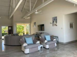 a living room with two chairs and a couch at Ocean View Villa with pool in Christ Church
