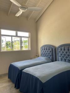 a bedroom with two beds and a ceiling fan at Ocean View Villa with pool in Christ Church +27 photos