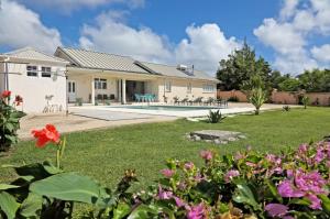 a house with a yard with flowers at Ocean View Villa with pool in Christ Church