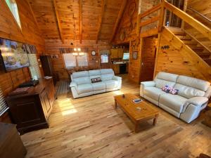 a living room with couches and a staircase in a cabin at Honeys Haven in Morganton
