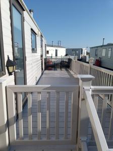 a deck with tables and chairs on a house at GnT Caravan lets in Anderby