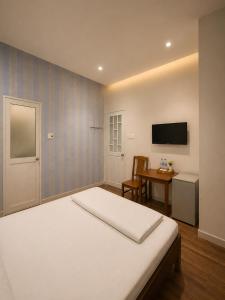 a bedroom with a bed and a desk and a television at Salyna Motel in Danang +40 photos