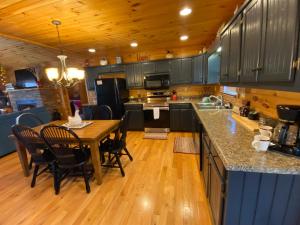 a kitchen with a wooden floor and a table with chairs at Lallybroch in Morganton