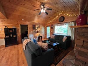 a living room with couches and a ceiling fan at Lallybroch in Morganton