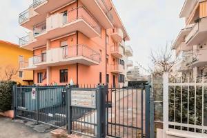 a building with a fence in front of it at Rifugio a due passi dal mare in Rimini