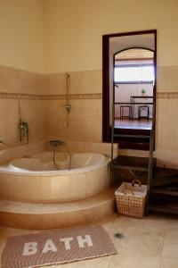 a bath tub in a bathroom with a mirror at Sunny's Suite in Safed