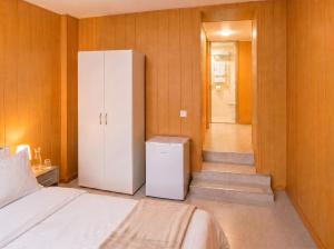 a bedroom with a bed and a white refrigerator at Pension Elisa in Rheinfelden +11 photos