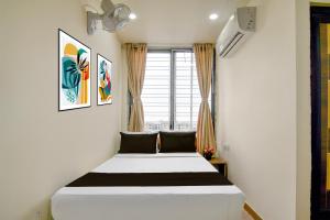 a bed in a room with a window at Hotel O B&B Guest House in kolkata
