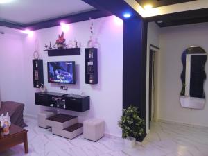 a living room with a tv on a wall at Appartement Saket Plage in Taranimt