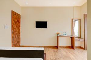 a bedroom with a bed and a table and a mirror at Hotel O B&B Guest House in kolkata +21 photos