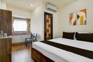 a bedroom with a bed and a chair in it at Hotel O B&B Guest House in kolkata